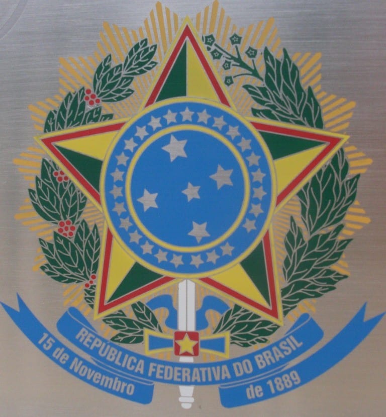BRASÃO DE ARMAS DO BRASIL - foi desenhado pelo engenheiro Artur Zauer, por encomenda do Presidente Manuel Deodoro da Fonseca. É um escudo azul-celeste, apoiado sobre uma estrela de cinco pontas, com uma espada em riste. Ao seu redor, está uma coroa formada de um ramo de café frutificado e outro de fumo florido sobre um resplendor de ouro.